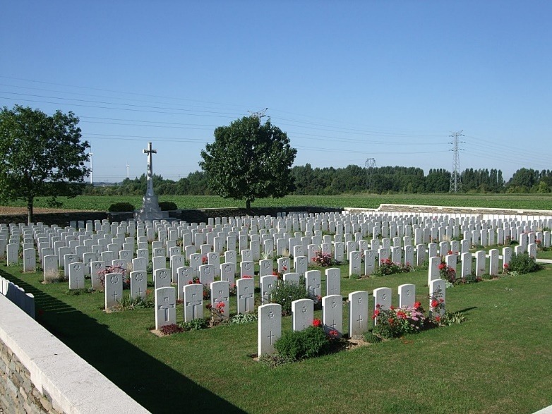 A cemetery with many white headstones Description automatically generated